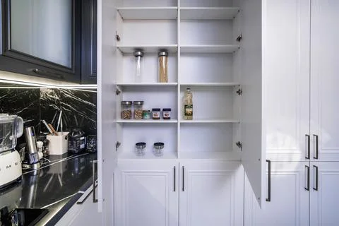 Open cabinets in a new kitchen set. Almost empty shelves Stock Photos