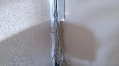 Open cable trunking with white cables, light and shadow on a textured wall Stock Footage 336868442