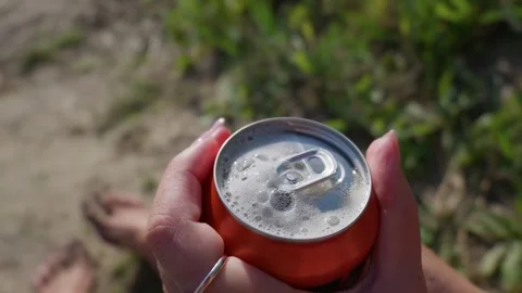 Open Can of Fizzy Soda Bubbling in Hands Outdoors in Slow Motion Stockbeeldmateriaal 344770163