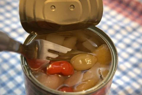 Open canned fruit salad with fork close-up Fotos Stock
