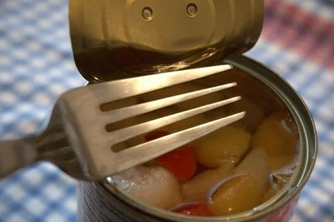 Open canned fruit salad with fork close-up Stockfoto's