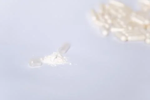 Open capsule with lactobacilli on the background of many capsules on a white Stock Photos