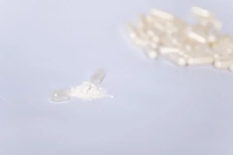 Open capsule with lactobacilli on a mixed background. There are many capsul.. Stock-Fotos