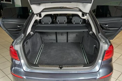Open car trunk and doors. gray upholstery. folding rear seat back and head Stock Photos