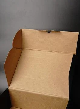 An open cardboard box on a black background. Dimmed lights Stock Photos