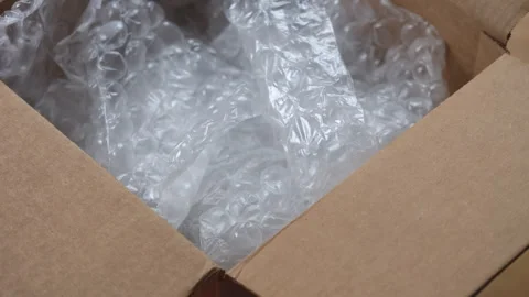 An open cardboard box with bubble wrap inside. Close up. Stock Footage 317771514