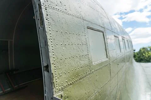 Open cargo hatch of a weathered, large airplane under overcast conditions N.. Stock Photos
