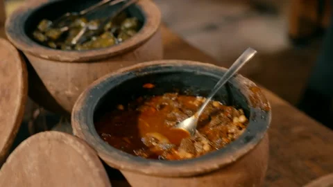 Open ceramic pots with prepared Middle Eastern food. Video stock 231141168