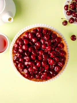 Open cherry pie on the kitchen table, on a cake pan, on a green background. T Foto stock