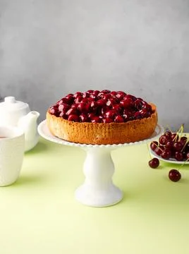Open cherry pie on the kitchen table, on a cake pan, on a green background. T Foto stock