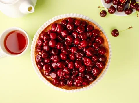 Open cherry pie on the kitchen table, on a cake pan, on a green background. T Foto stock