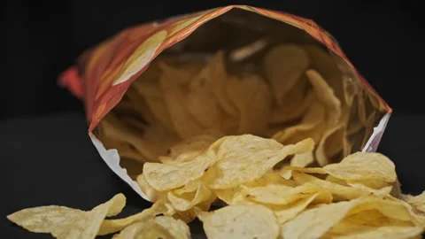 An Open Chips Pack Rotates on a Black Background Close-Up Stock Footage 260042957