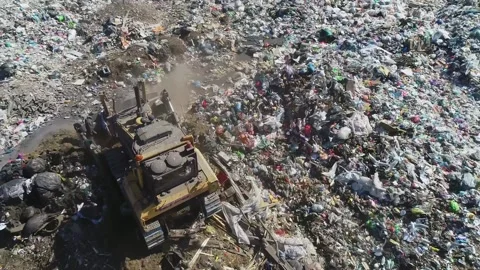 Open city garbage dump. Birds are flying, a bulldozer is leveling piles of waste Video stock 150017745