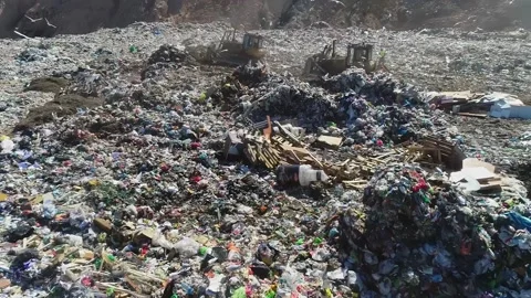 Open city garbage dump. Birds are flying, a bulldozer is leveling piles of waste Stock Footage 150017890