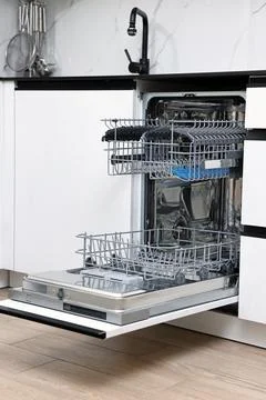 Open clean empty dishwasher in kitchen. Home appliance Stock Photos