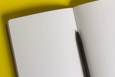 An open, clean notebook or notebook and a pen on the table.Close-up. Stock Photos