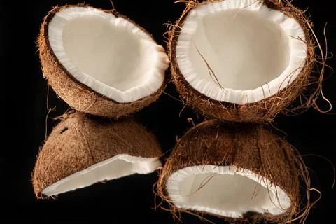 Open coconut placed on a reflective surface, black background, selective focu Foto stock