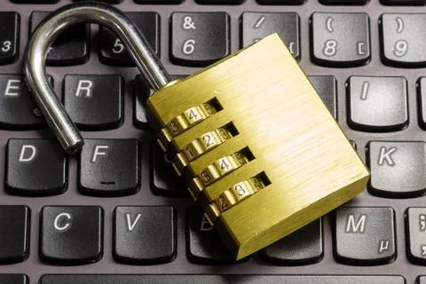Open combination padlock on a laptop keyboard symbolizing data security Foto stock