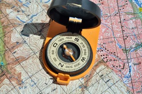 Open compass on the maps. Stock Photos