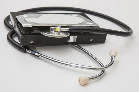 Open computer hard drive and phonendoscope on a white background. Stock Photos