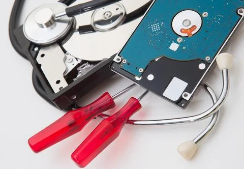 Open computer hard drive and phonendoscope on a white background. Stock Photos