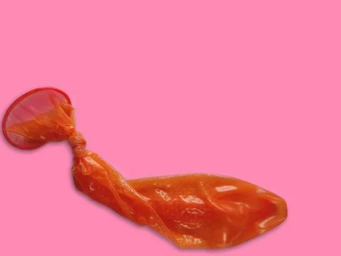 Open Condom thrown after use knot on end to protect sperms spillage Stock Photos