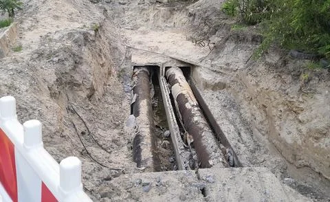 Open construction trench with old heating pipes undergoing repair and repla.. Stock Photos