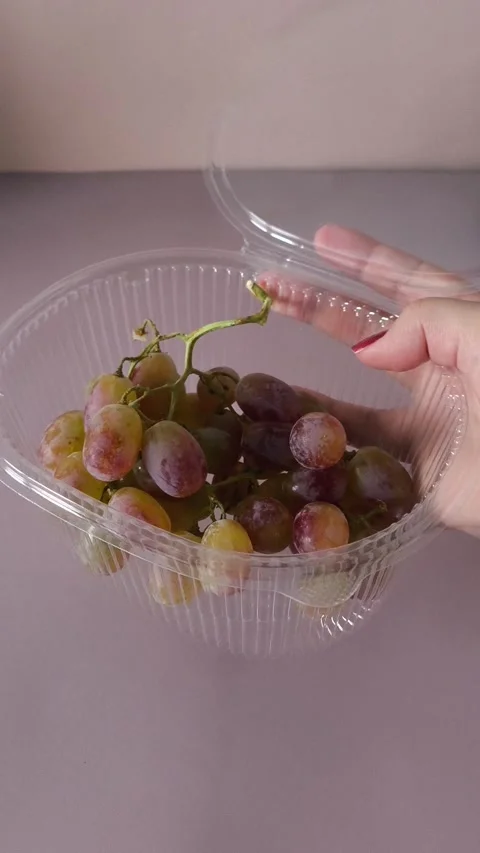 Open container of Taifi grapes in a womans hand close-up. Storing berries Stock Footage 324770069