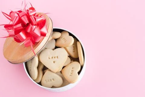 Open cookie box with decorations on a pink background. Copy space. Stock Photos