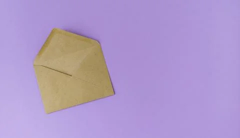 Open craft brown envelope on a light purple background. Stock Photos
