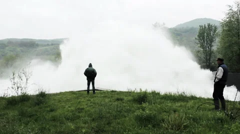 Open dam discharged a large amount of water from lake reservoir, 2 man standing. Stock Footage 37795118