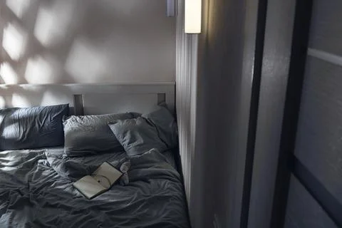 Open diary to write on the bed with blue textiles in the moonlight. Evening Stock Photos