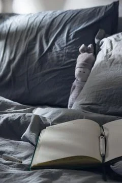 Open diary to write on the bed with blue textiles in the moonlight. Evening Stock Photos