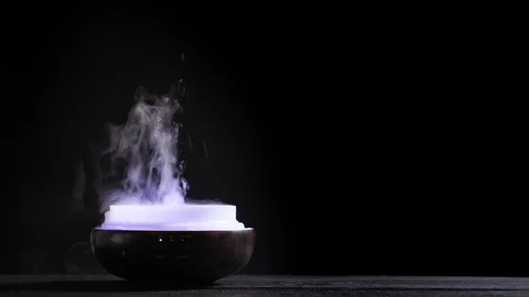 Open diffuser for essential oils diffusing steam on black background Stock Footage 122694497