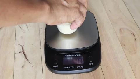 Open the digital weighing scale by hand and weigh the rice Stock Footage 282627829
