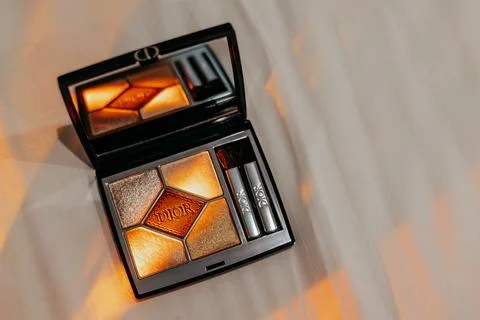 An open Dior eyeshadow palette with applicators in a ray of light Stock Photos