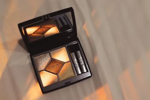 An open Dior eyeshadow palette with applicators in a ray of light Stock Photos
