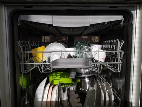 Open dishwasher with clean utensils inside, closeup view Stock Photos