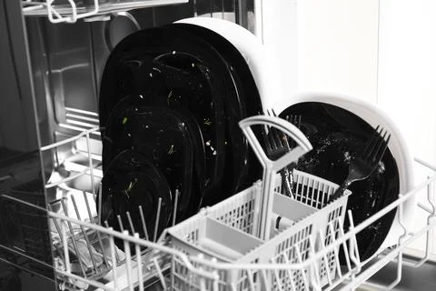 Open dishwasher with dirty tableware in kitchen, closeup Stock Photos