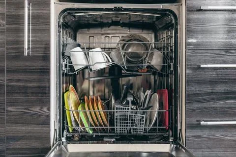 Open dishwasher with dishes built into the kitchen Stock Photos