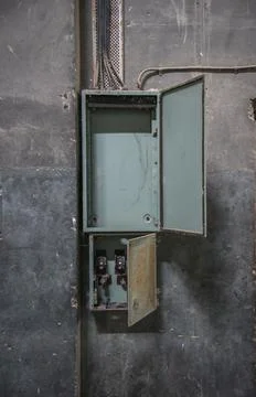 Open distribution panel box on concrete wall in abandoned building Stock Photos