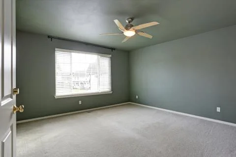 Open door to an Empty room with grey ceiling and grey walls paint color. Stock Photos