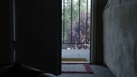 An open door inside of a dark apartment leading to an outdoor hallway at an Vidéo 93806028