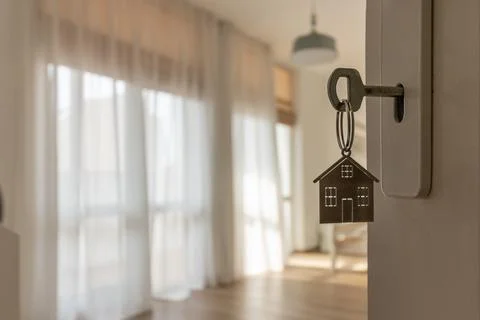 Open door to a new home with key and home shaped keychain. Mortgage, investme Stock-Fotos