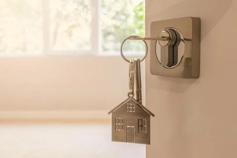 Open door to a new home with key and home shaped keychain. Mortgage, invest.. Stock Photos