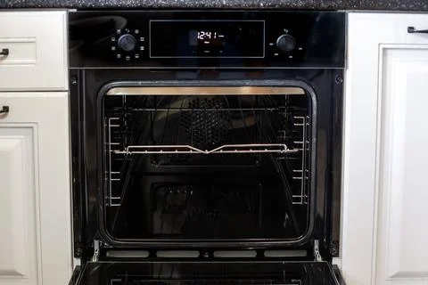 The open door of a new oven with visible racks, ready for cooking Stockfoto's
