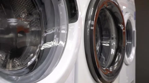 Open the Door of the Washing Machine. A Customer Inspects a New Washing Machine Stock Footage 152529894