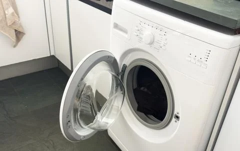 Open door washing machine on a white and wood background Stock Photos