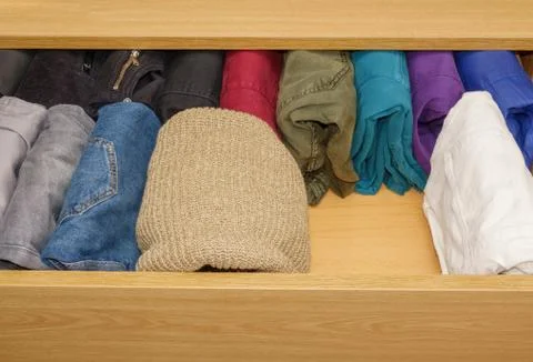 Open drawer with trouser and wool sweaters with free space Stock Photos