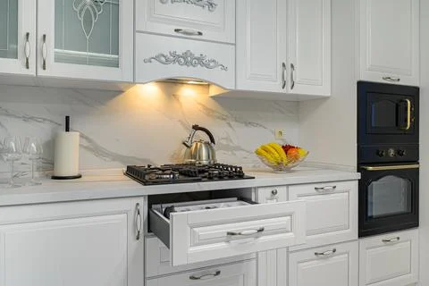 Open drawers with kitchenware at modern white kitchen Stock Photos